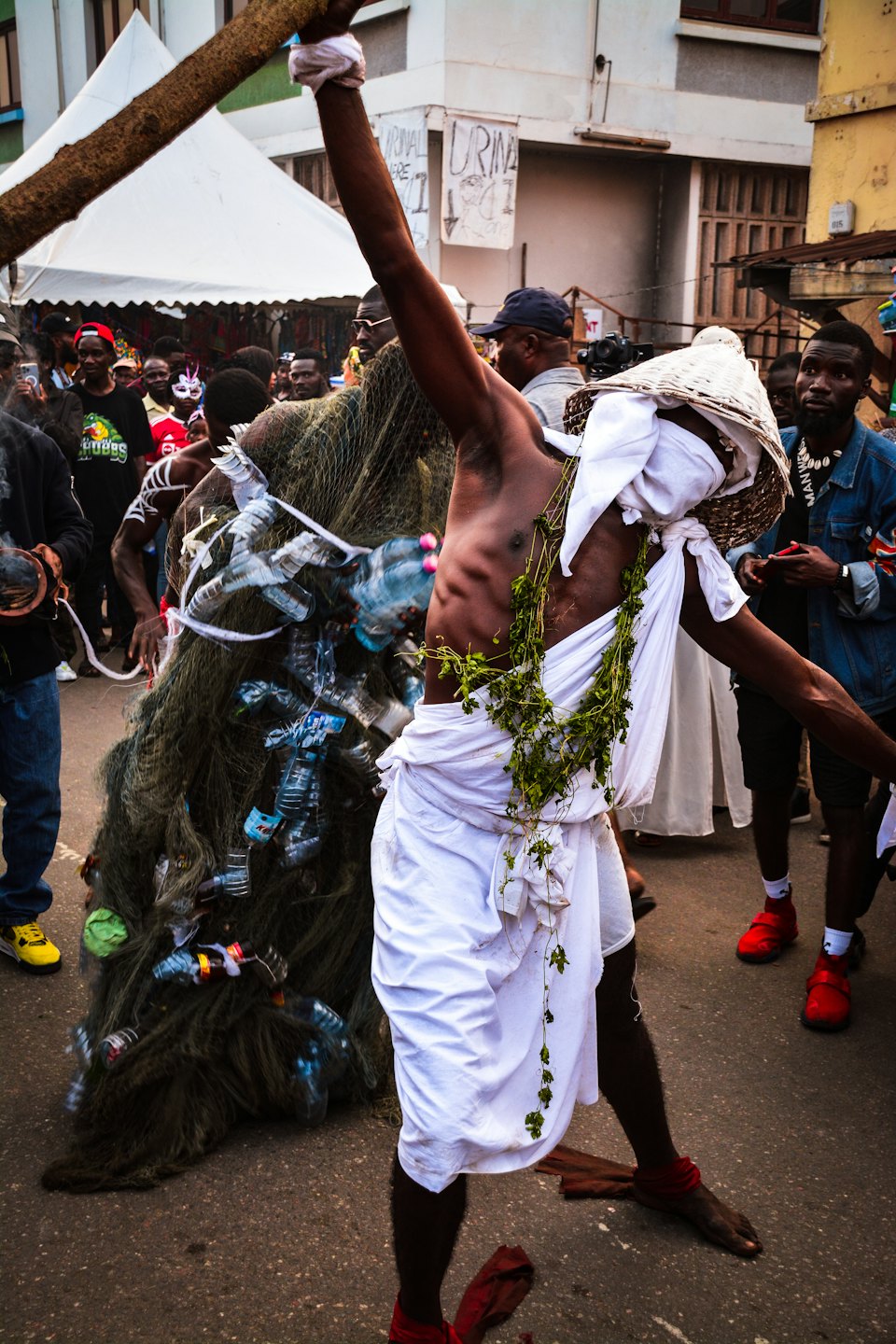 Performers in traditional costumes parade through a busy city street.